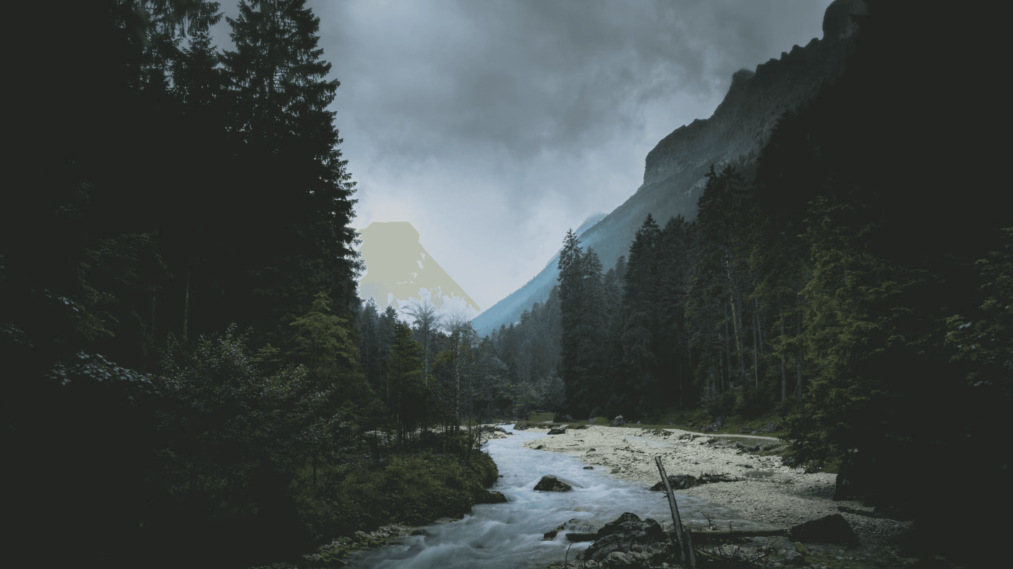 Dunkle Berglandschaft in Garmisch-Partenkirchen mit wildem Flusslauf im dichten Nadelwald